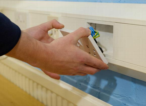 man inserting plug socket in electrical panel 